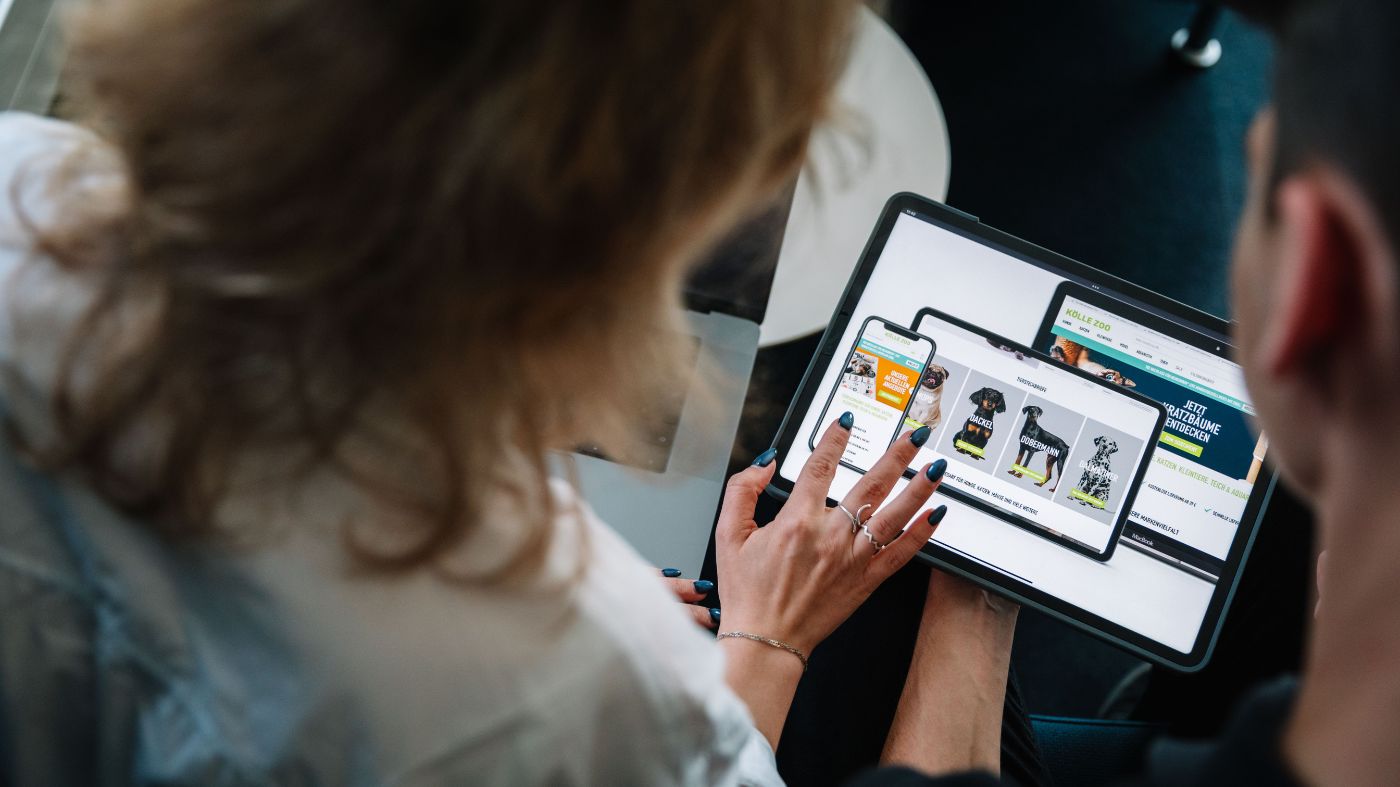 Onlineshop optimieren Eine Frau und ein Mann, sitzen zusammen und schauen auf ein Tablet.